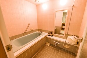 Un baño con bañera, lavabo y espejo.