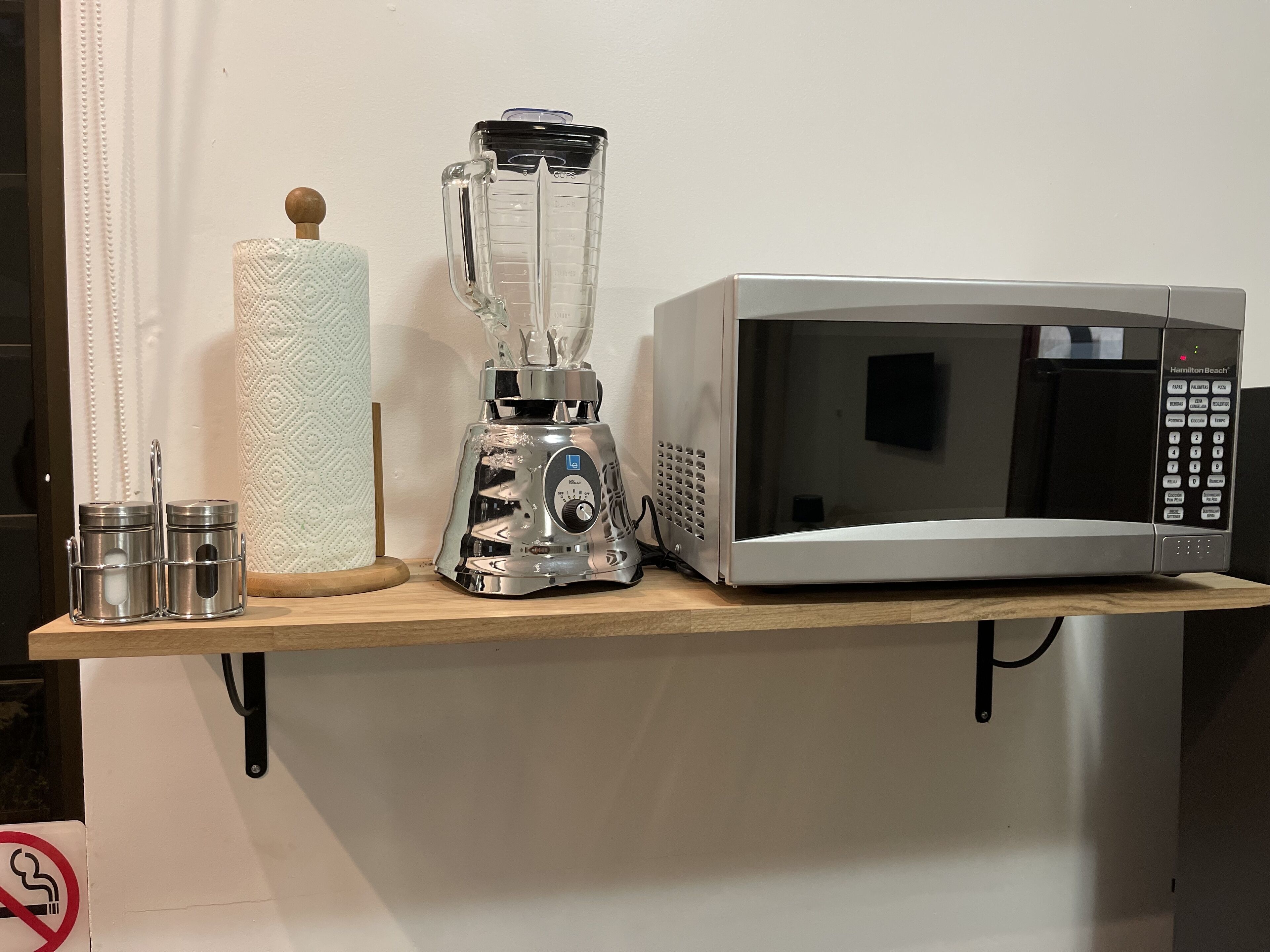Eine Küchenarbeitsplatte mit einem Mixer, einer Mikrowelle und zwei Edelstahlbehältern.