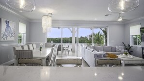 A spacious living area with a large dining table, comfortable seating, and a view of the outdoors.