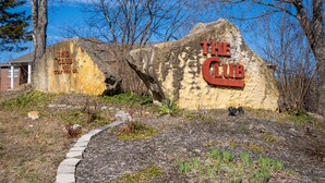 A large rock with 'The Club' sign, a pathway, and surrounding trees. - Beautiful condo in Branson (Branson)