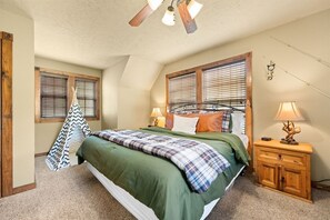 A bedroom with a bed, two bedside tables, a hanging chair, and a ceiling fan. - 4 King Suites | Near Silver Dollar City (Branson West)