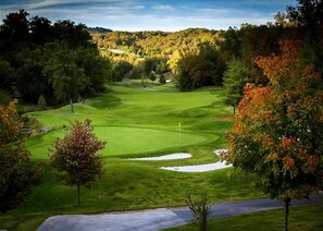 A golf course with a clear path, sand bunkers, and a flag on the green. - 4 King Suites | Near Silver Dollar City (Branson West)