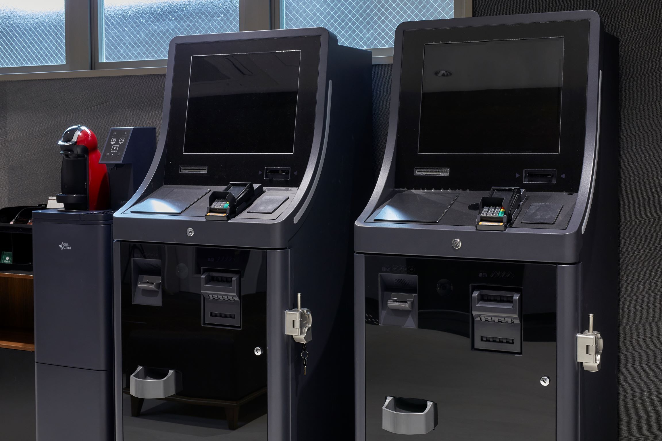 Two self-service kiosks with card readers and a coffee machine.