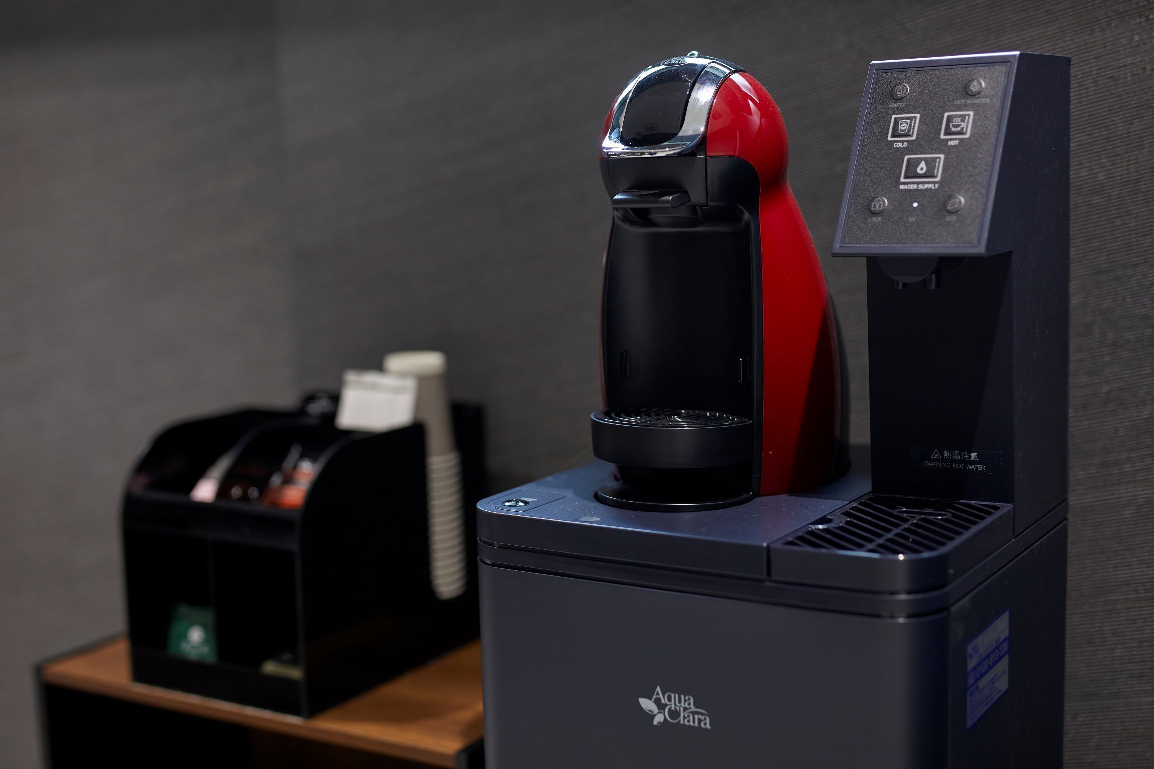 Máquina de café com interface digital e dispensador de água em bancada.