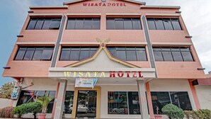 Un edificio de varios pisos con el letrero "WISATA HOTEL" bien visible.