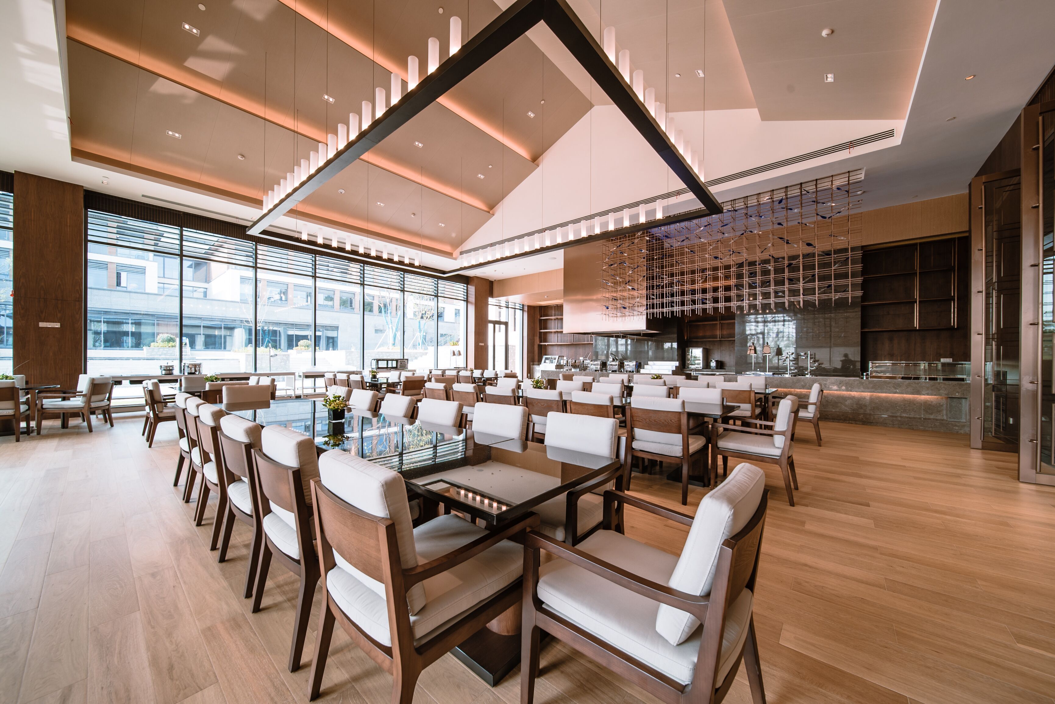 A spacious dining area with modern furniture and large windows offering views of the cityscape.
