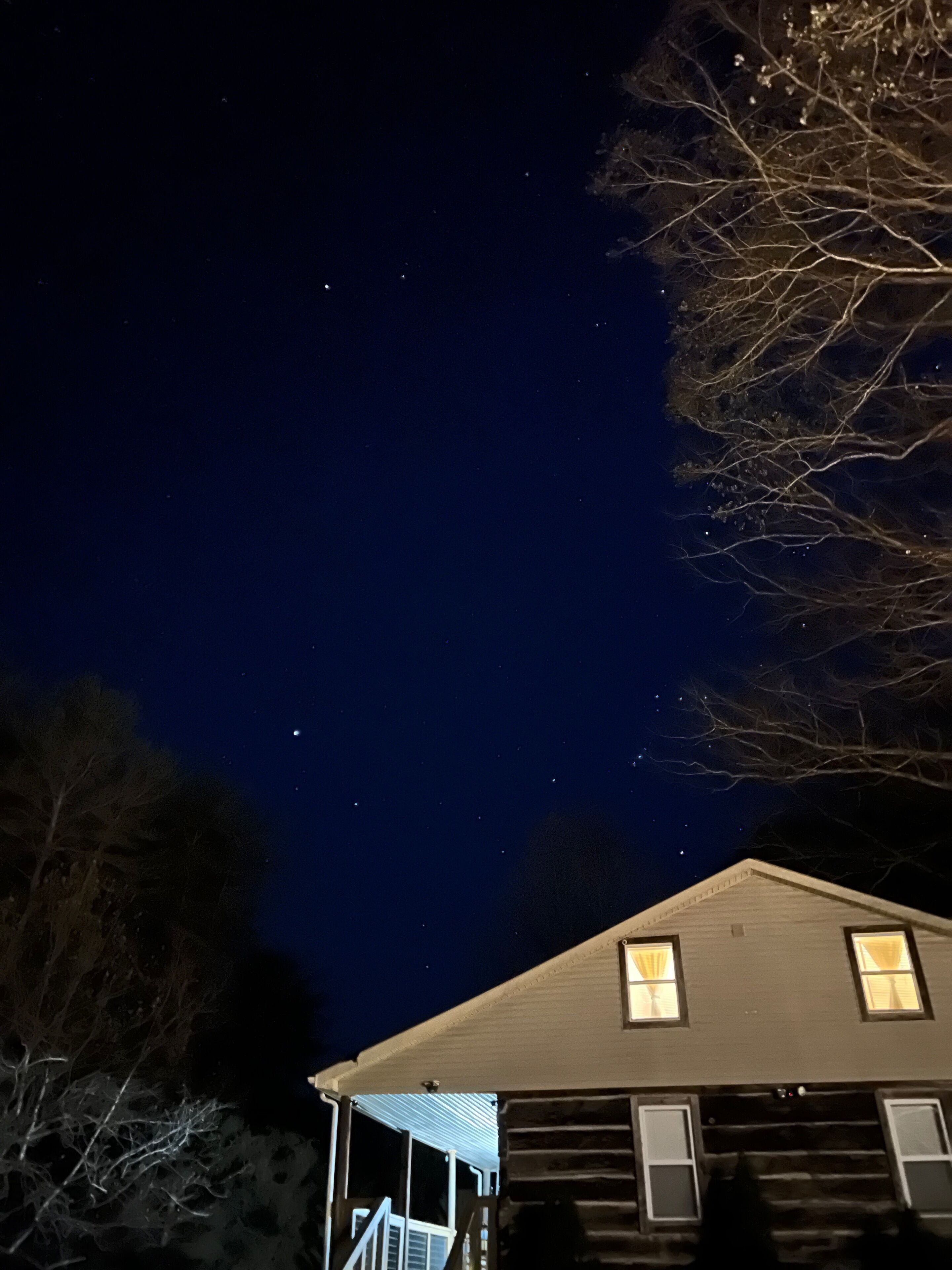 A house with a porch and a starry night sky.