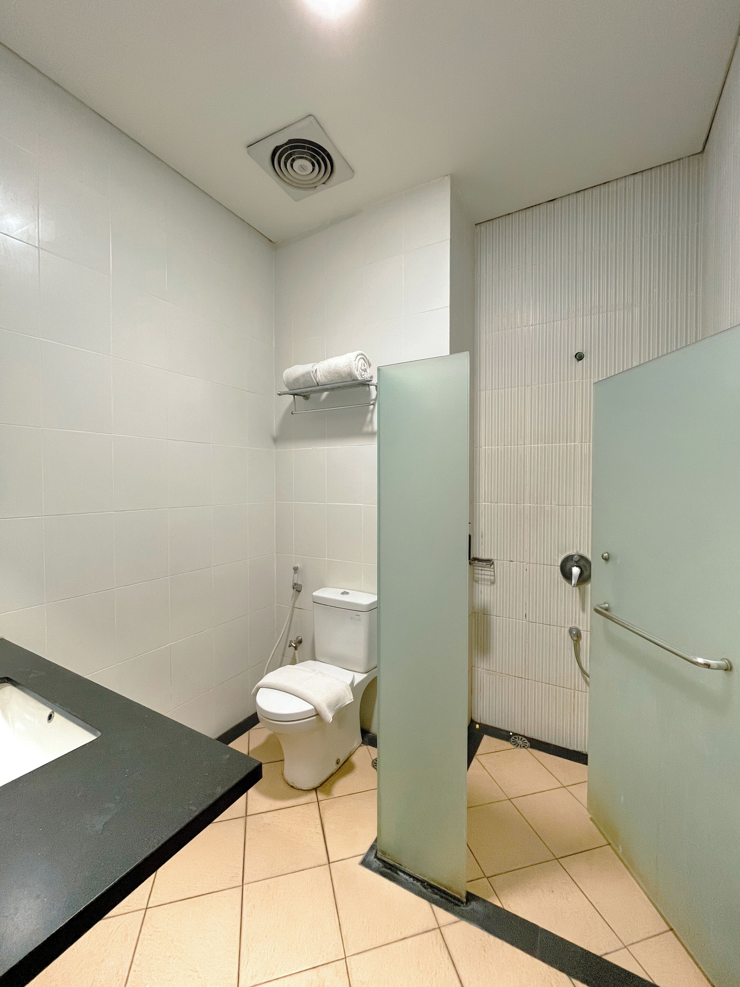 A restroom with a toilet, a sink, and a mirror.