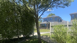 A residential area with a well-maintained lawn, a wooden fence, and houses in the background. - Yarra Cottage (Yarra Junction)
