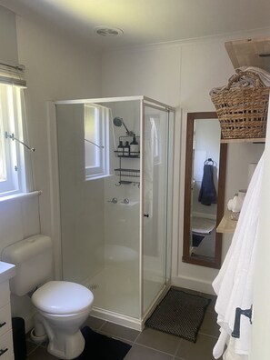Enjoy a refreshing shower in the sleek bathroom with a glass-enclosed shower and handheld showerhead.