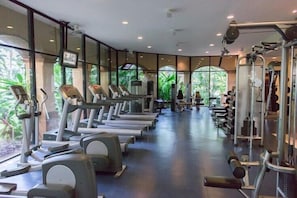 Uma academia com esteiras, elípticos e equipamentos de musculação.