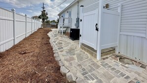 A white building with a stone pathway leading to a gated entrance.