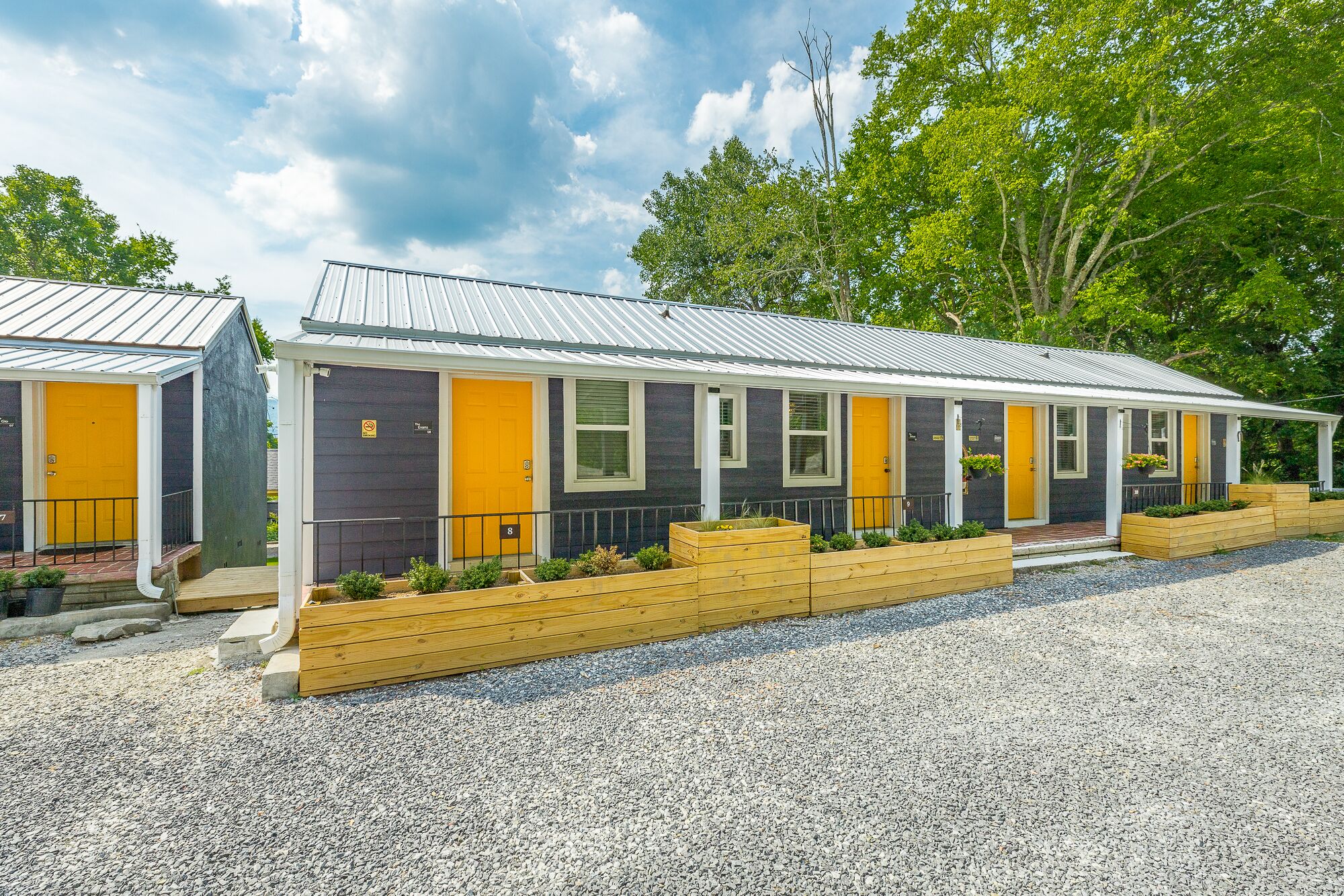 A row of two-story mobile homes with yellow doors, each with a number on the front.