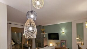 A dining area with a round table set for four, a sofa, and a TV mounted on the wall. - House in Begur with swimming pool and castle view - 3 bedrooms, sleeps 5 to 6 (Begur)