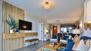 A modern living room with a sofa, coffee table, and a TV mounted on a wooden wall.