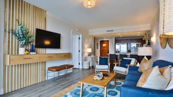 A modern living room with a sofa, coffee table, and a TV mounted on a wooden wall.