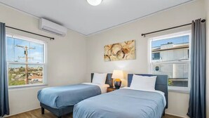 A room with two beds, a nightstand, a lamp, and a painting on the wall. - Breathtaking View 2BD/1BTH Unit in Central SD (San Diego)