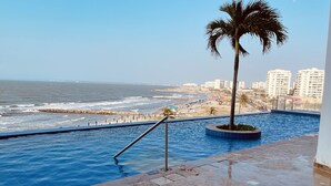 Una piscina con vista a la playa y al océano.