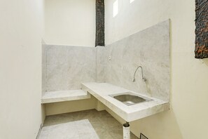 A small, modern bathroom with a white sink, a mirror, and a toilet. - SPOT ON 90882 Sari Homestay Near Garuda Wisnu Kencana (Ungasan)