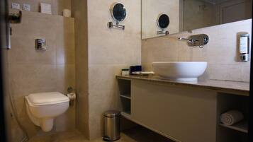 A modern bathroom with a toilet, bidet, and a large sink.