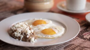 Um prato com dois ovos fritos e uma porção de arroz.