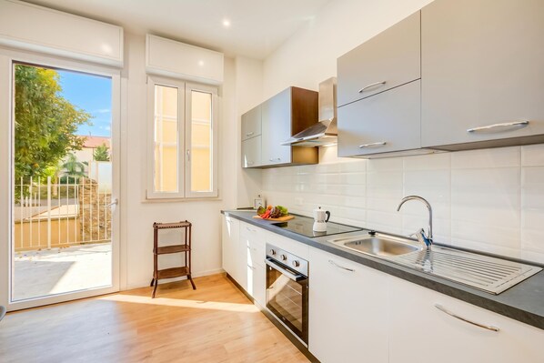 A modern kitchen with a large window, a built-in oven, and a sink.