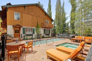 Un bâtiment en bois doté d’une piscine et d’un espace extérieur aménagé pour s’asseoir.