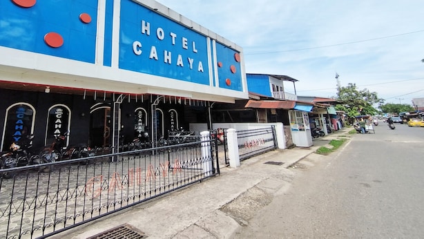 A hotel with a blue facade and red circular decorations. - OYO Life 92291 Hotel Cahaya Syariah (Tungkal Ilir)
