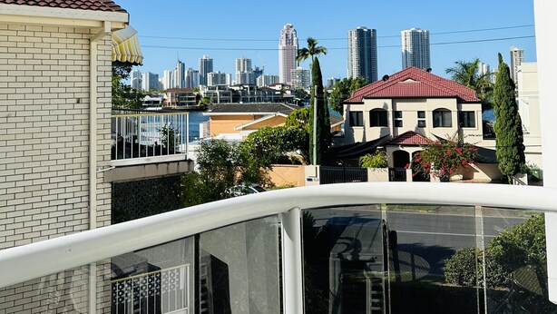 A residential area with a view of a city skyline, featuring tall buildings and a clear blue sky. - Modern Apartment in Chevron Island (Surfers Paradise)