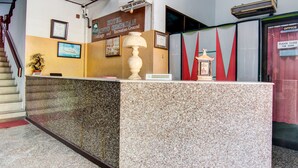 Un comptoir d’accueil d’hôtel avec une pancarte indiquant qu’il s’agit de l’hôtel Rindu Sempadan, qui dispose également de chalets et d’un espace de loisirs.
