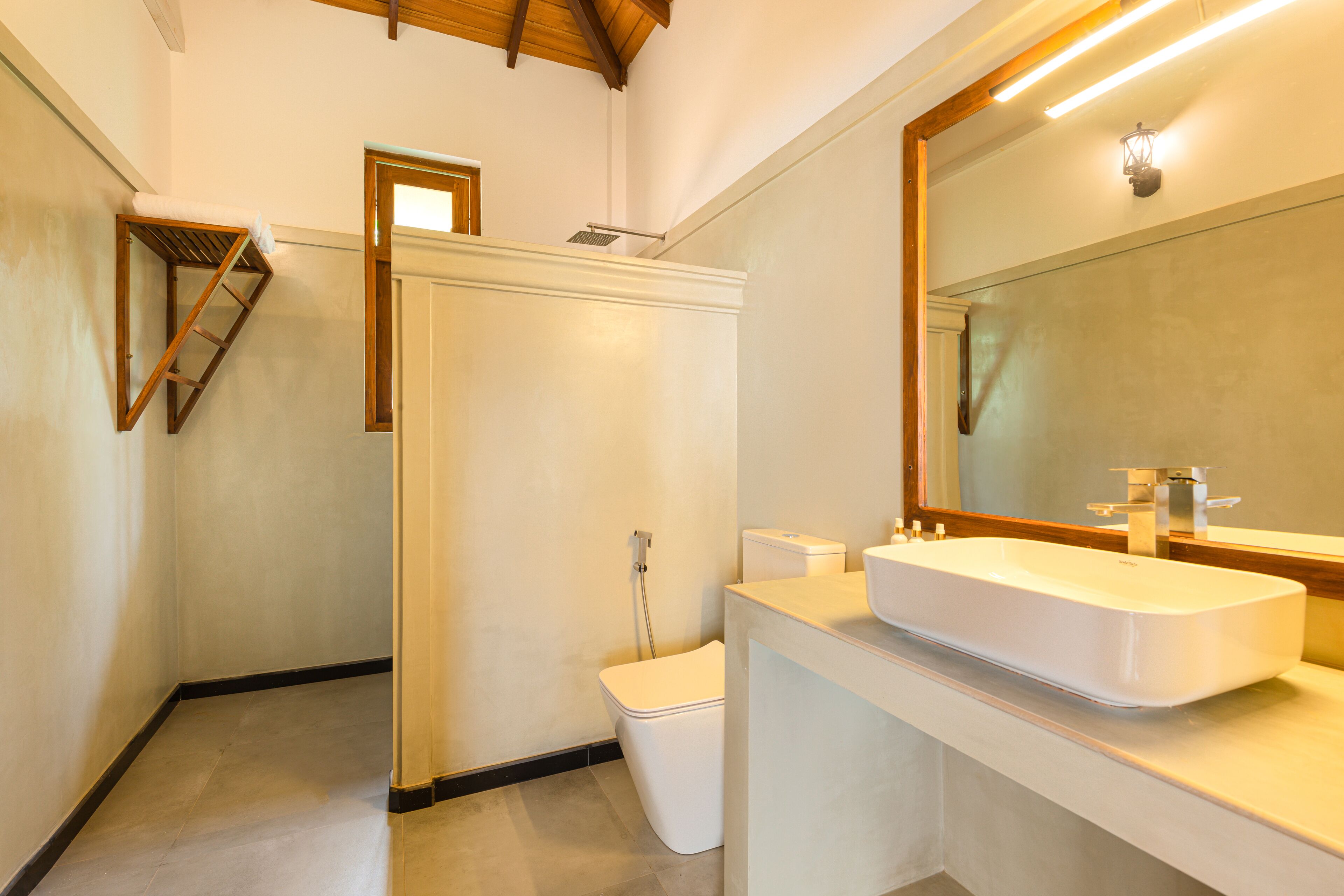 A bathroom with a white sink, a mirror, and a toilet.