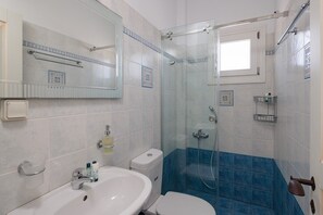 A bathroom with a shower, toilet, sink, and a mirror. - 9 Muses Naxos beach hotel (Naxos)