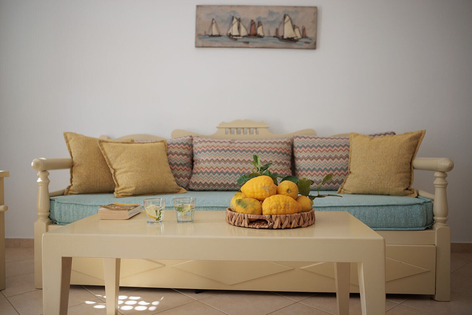 Un salon avec un canapé, une table basse et un tableau accroché au mur.