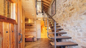 A wooden staircase with a stone wall, a wooden door, and a bench. - Le Refuge Cal Chalon ***** chalet in the heart of the village - its breathtaking view (Les Angles)