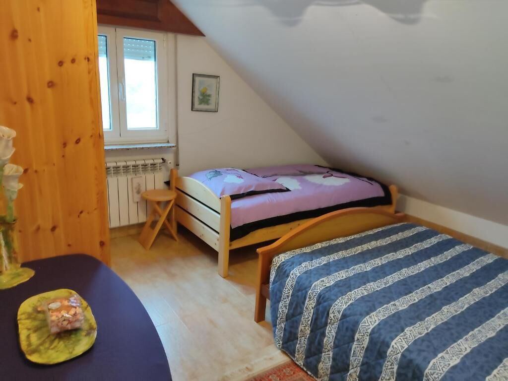 Ett litet, ombonat rum med en säng, ett träbord och ett fönster.