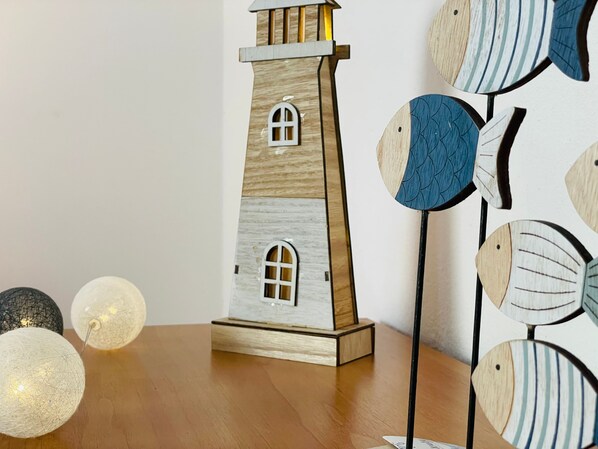 A wooden tower with arched windows, a table with spherical decorative lights, and a wall with circular wooden patterns.