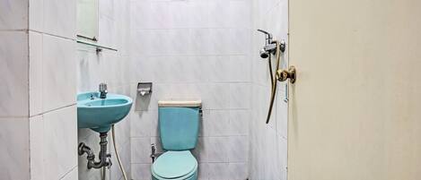 A small bathroom with a toilet, sink, and shower.