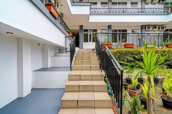 Un immeuble à plusieurs étages, doté d’un escalier central menant à un étage supérieur.