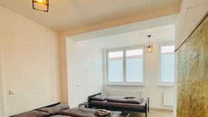 Een moderne slaapkamer met twee bedden, een houten vloer en een groot raam.