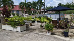 Une terrasse sur le toit, aménagée avec des espaces de détente en plein air, des jardinières et une piscine.