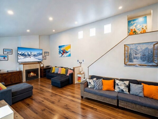 Ein modernes Wohnzimmer mit Kamin, Sofas und Kunstwerken an den Wänden.