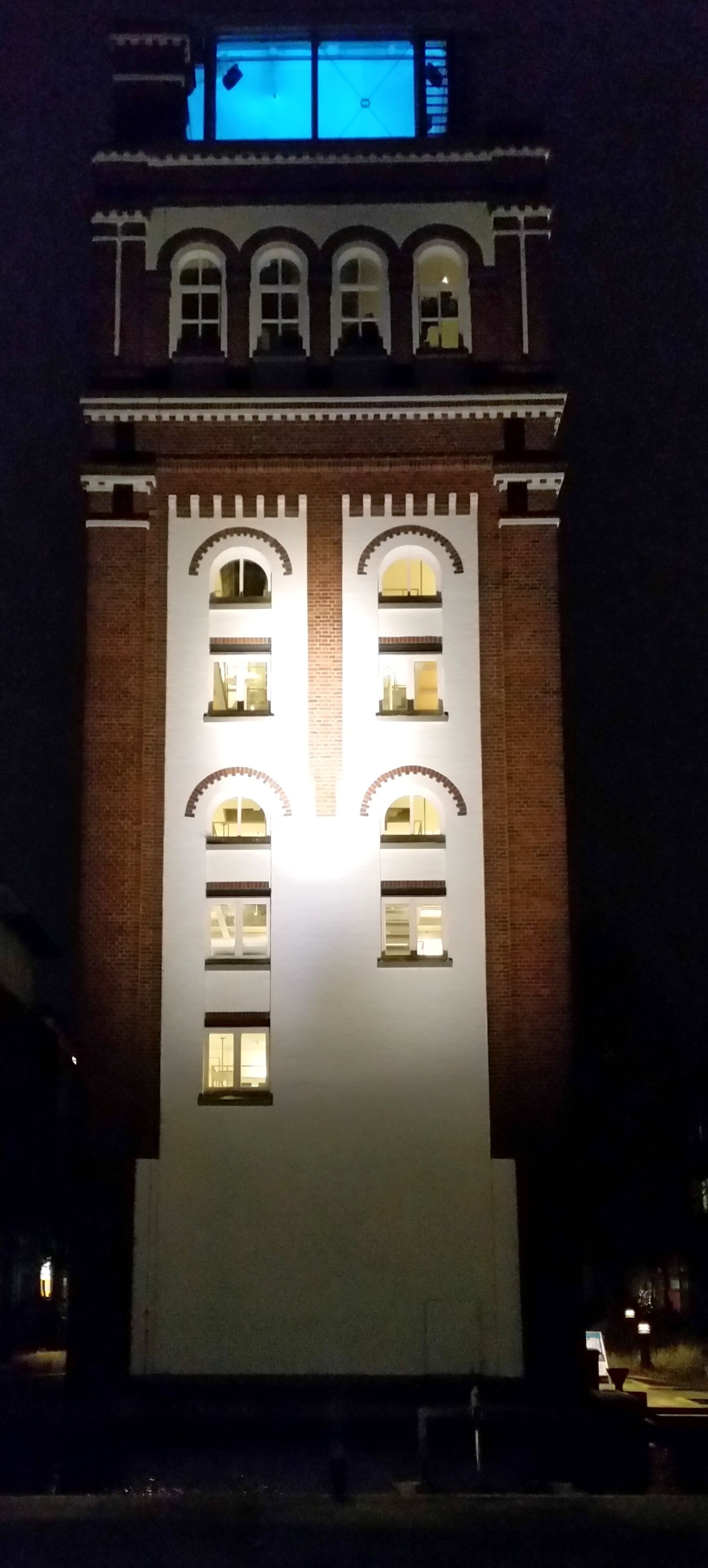 En bygning med en symmetrisk facade, mange vinduer og en midterindgang.