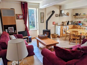 A cozy living room with a sofa, a TV, a lamp, and a fireplace.