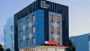 Un moderno edificio de hotel con el nombre "Hotel Nikhil Regency" bien visible.