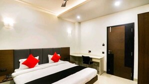 Una habitación de hotel con una cama, un escritorio y un armario.