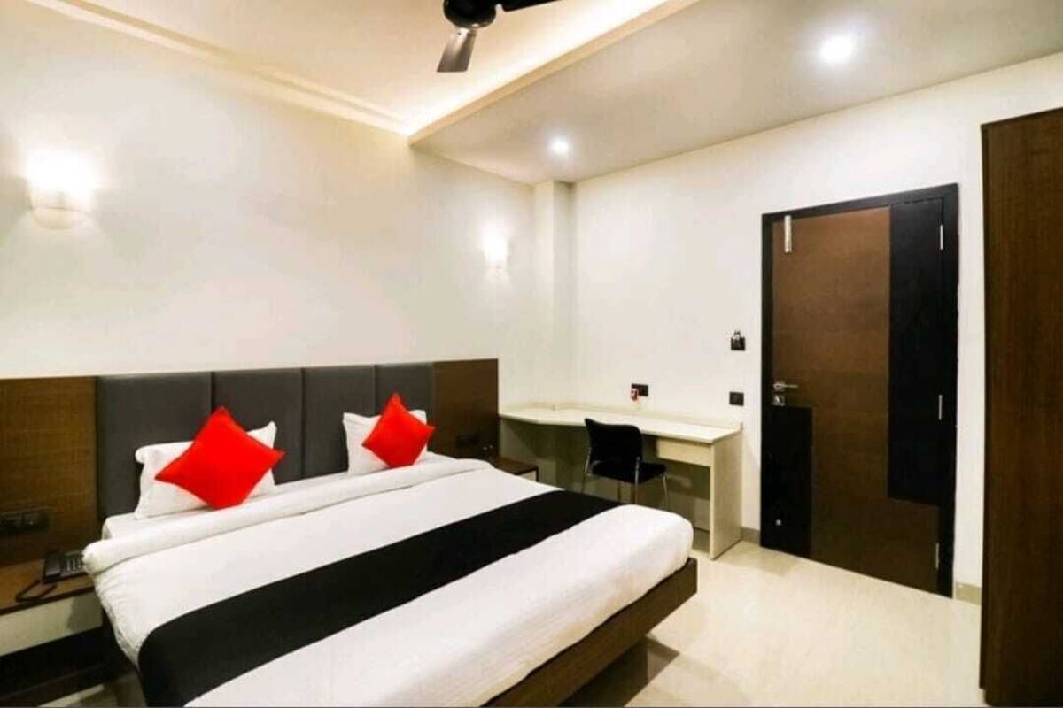 Una habitación de hotel con cama, escritorio y armario.