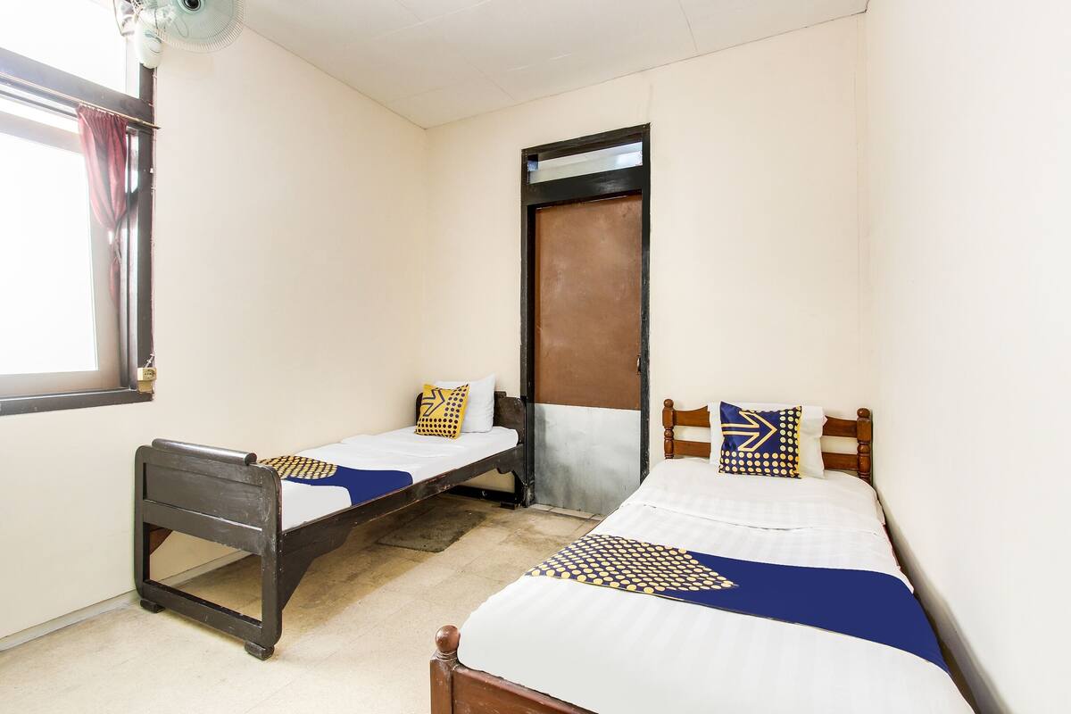 Habitación económica con 2 camas individuales | Espacio para trabajar con laptop y ropa de cama