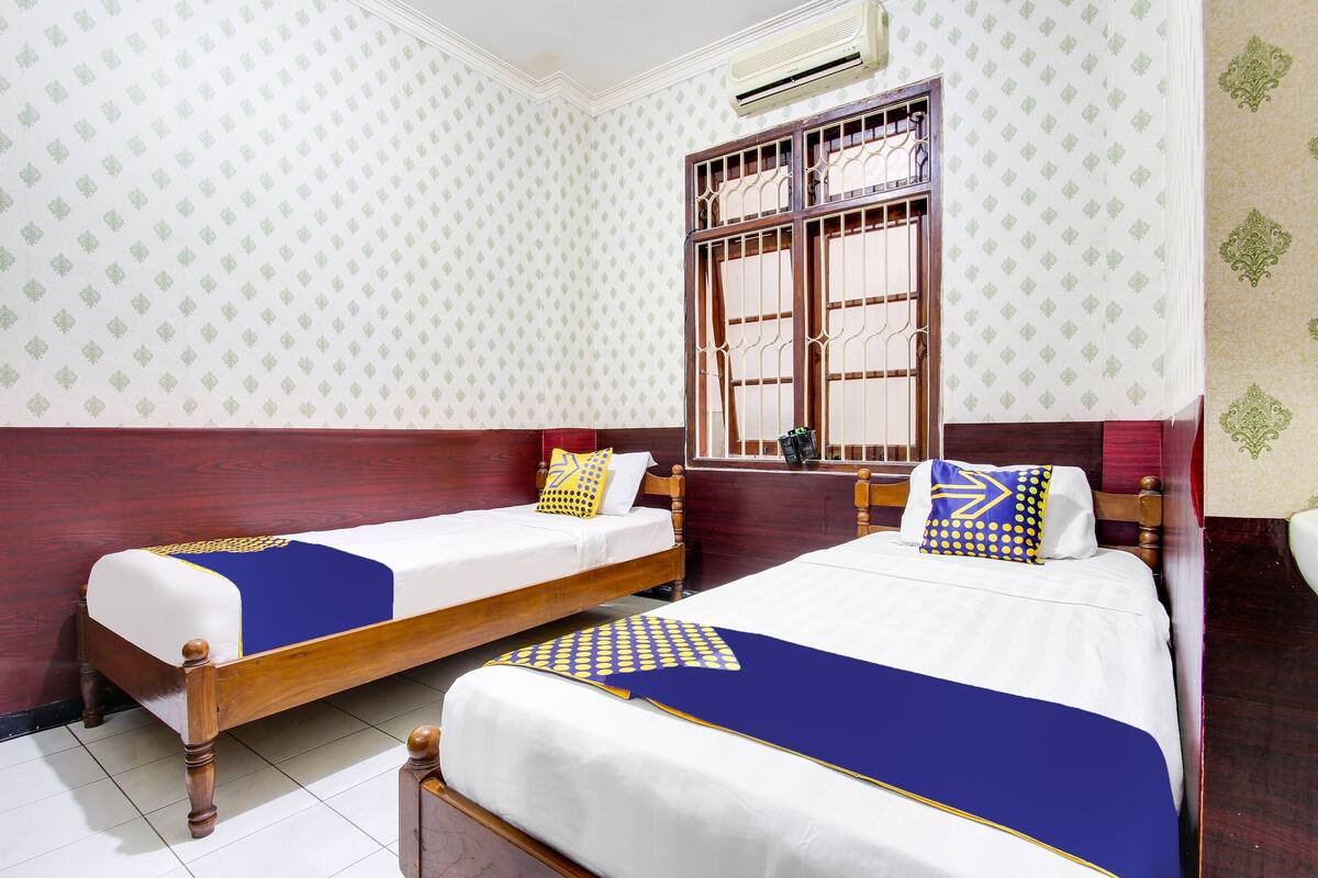 Habitación con 2 camas individuales | Espacio para trabajar con laptop y ropa de cama