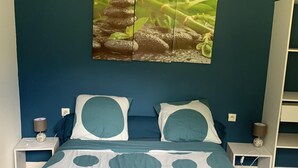 Quarto com cama, duas mesas de cabeceira, um quadro na parede e um guarda-roupa.