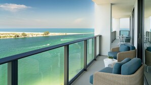 A balcony with wicker furniture, a small table, and a view of the ocean and beach. - JW Marriott Clearwater Beach Resort & Spa (Clearwater Beach)